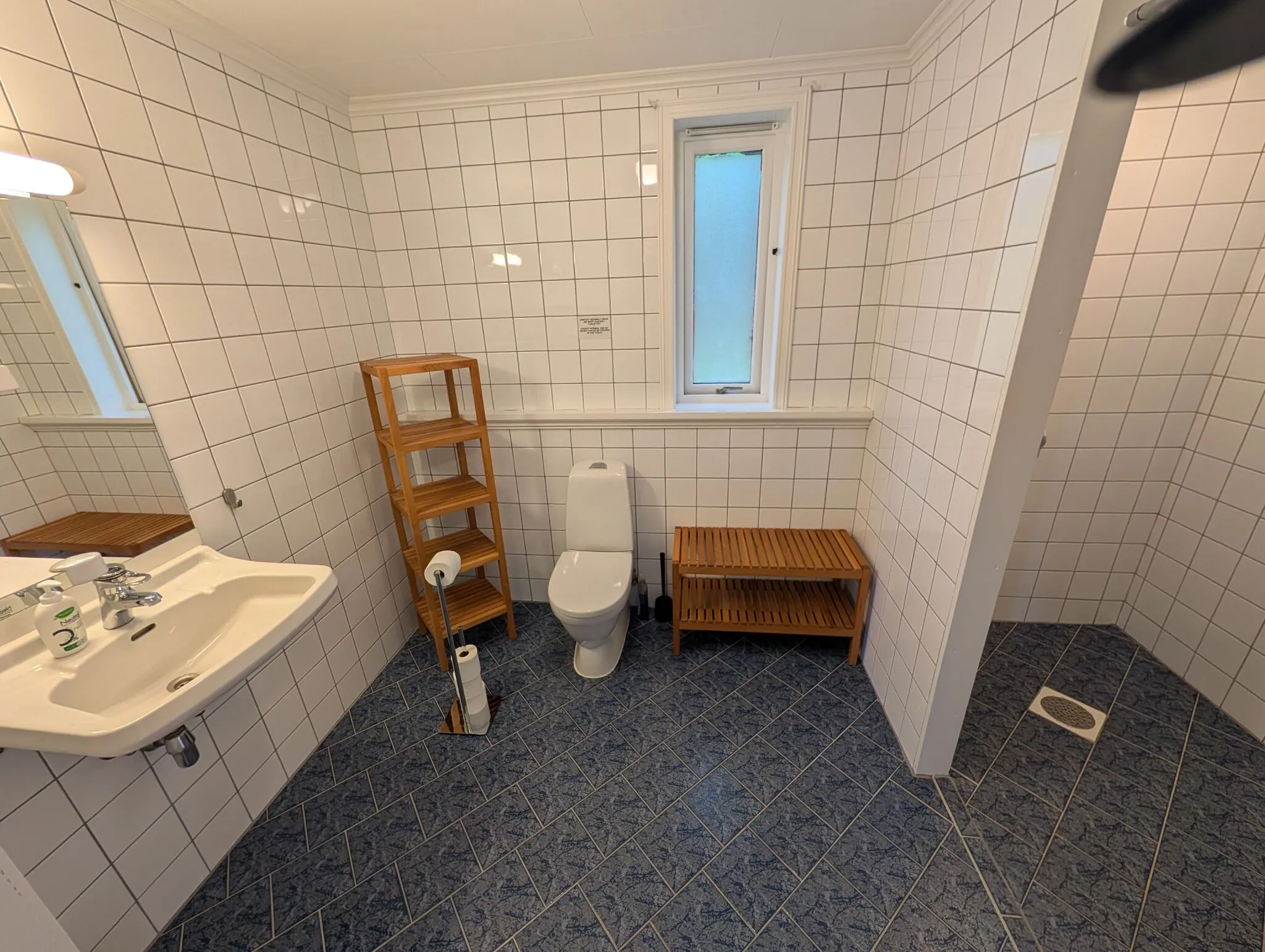 Stort tilpasset bad med terskelfri dusjsone, sklisikre fliser, servant og toalett